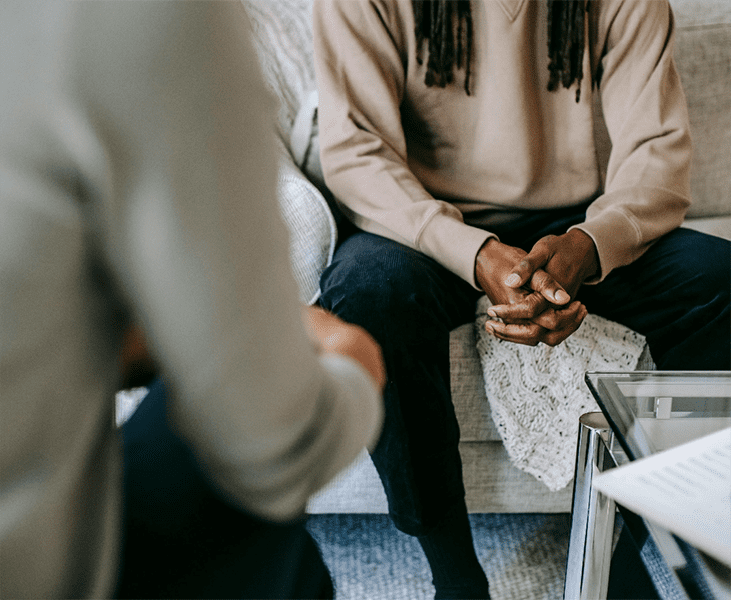 A person sitting on a couch speaking with a therapist. Integrea Community Mental Health System offers many services for those mental health illnesses and substance use disorders.