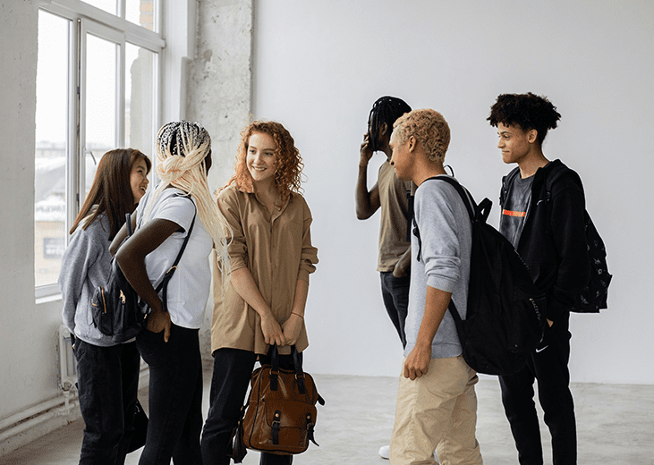 A group of high school aged students chatting in a room. Integrea Community Mental Health System maintains a Youth Advisory Board made up of high school students.